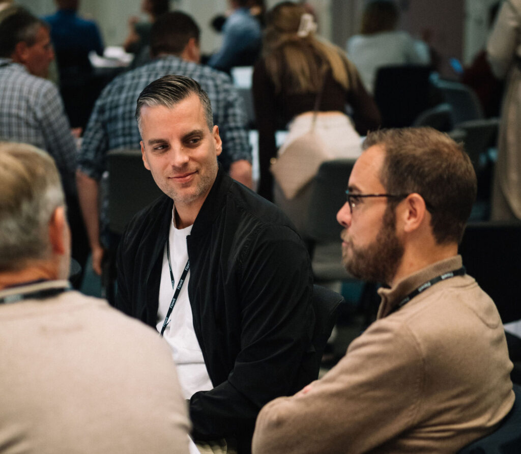 Personer på konferansen som diskuterer.